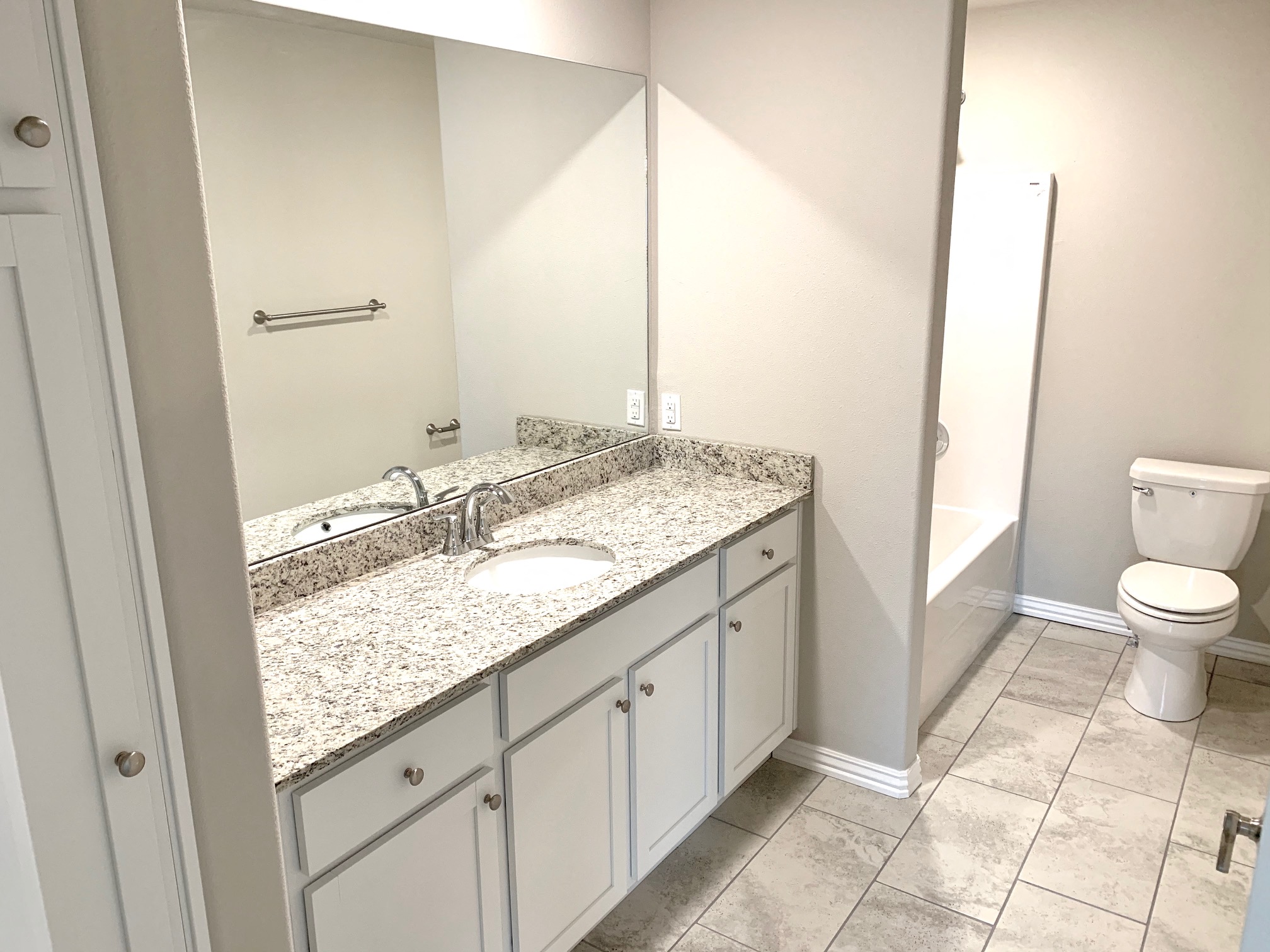 B1 (1-car) Master Bath with tile flooring, granite countertops, and sink