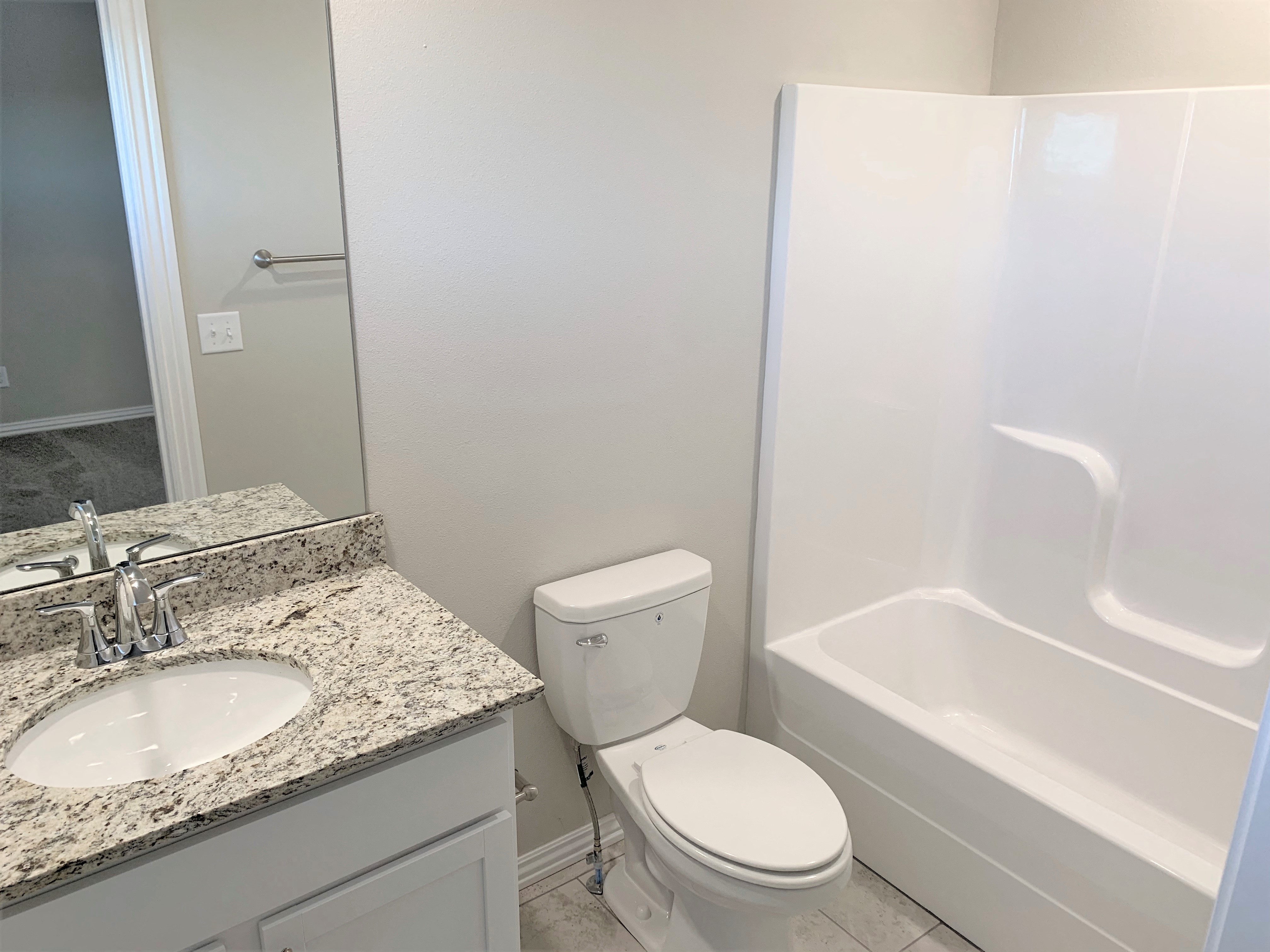 B2 (2-car) Guest Bath with granite countertops, sink, toilet, and shower