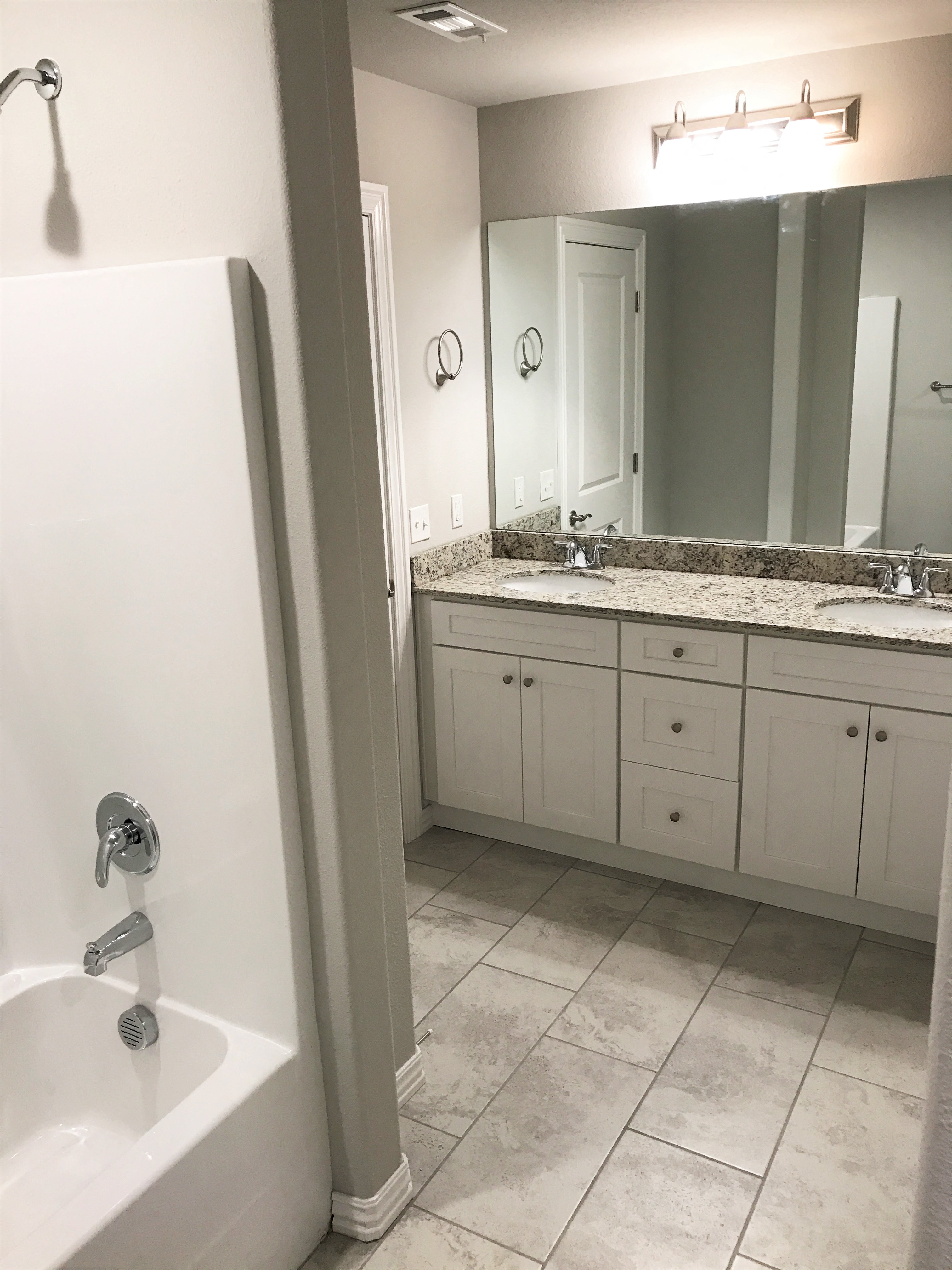C1 (1-car) Master Bath with double sink, tile flooring, and shower
