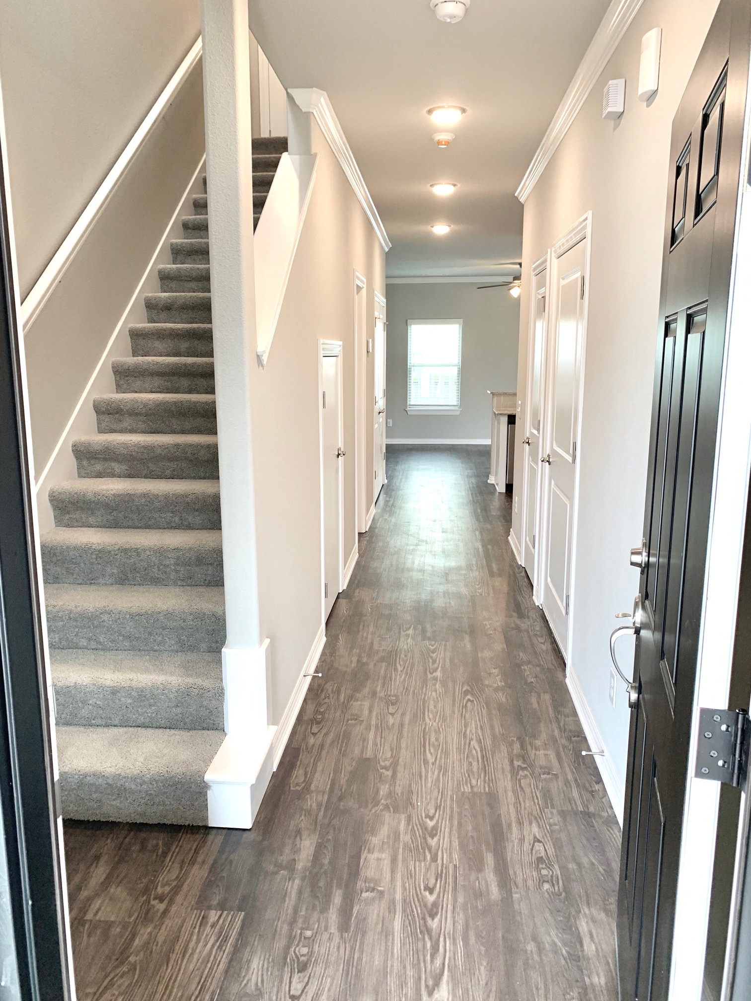 C1 (2-car) Entry with laminate wood flooring and staircase facing entry door