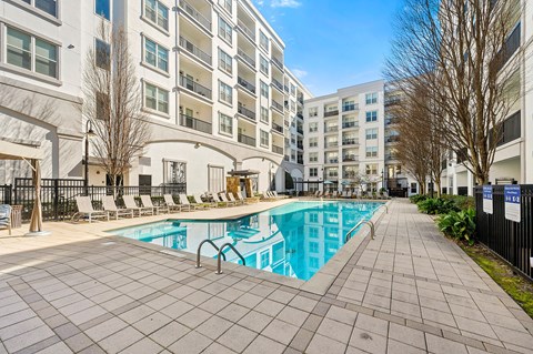A large swimming pool in front of apartment buildings.