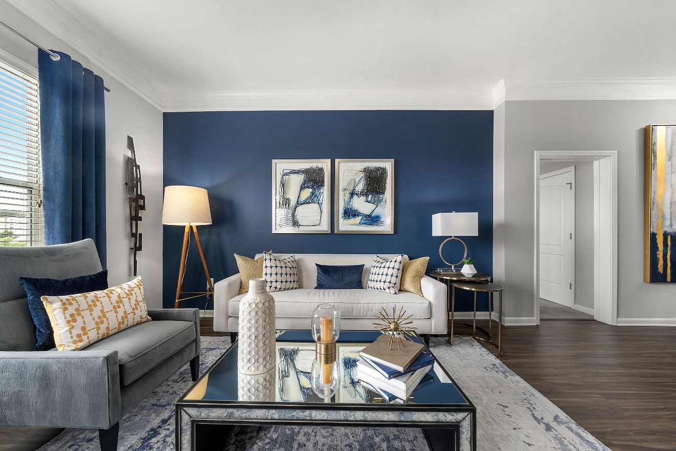a living room with a blue accent wall and a white couch