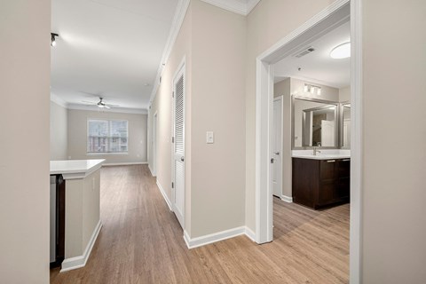 a renovated living room and kitchen with white walls and wood floors