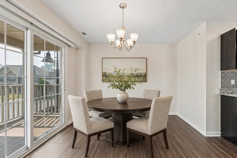 A dining room with a table and chairs.