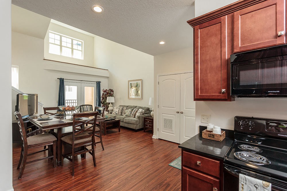 a kitchen and living room with a table and a microwave