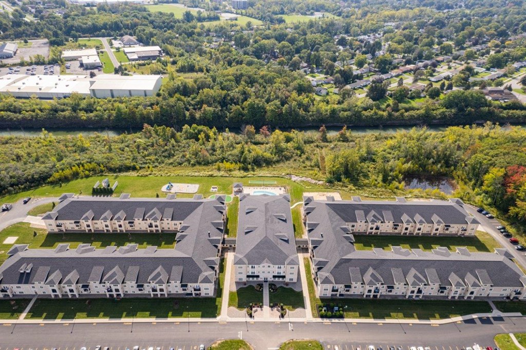 an aerial view of a building complex with trees in the background
