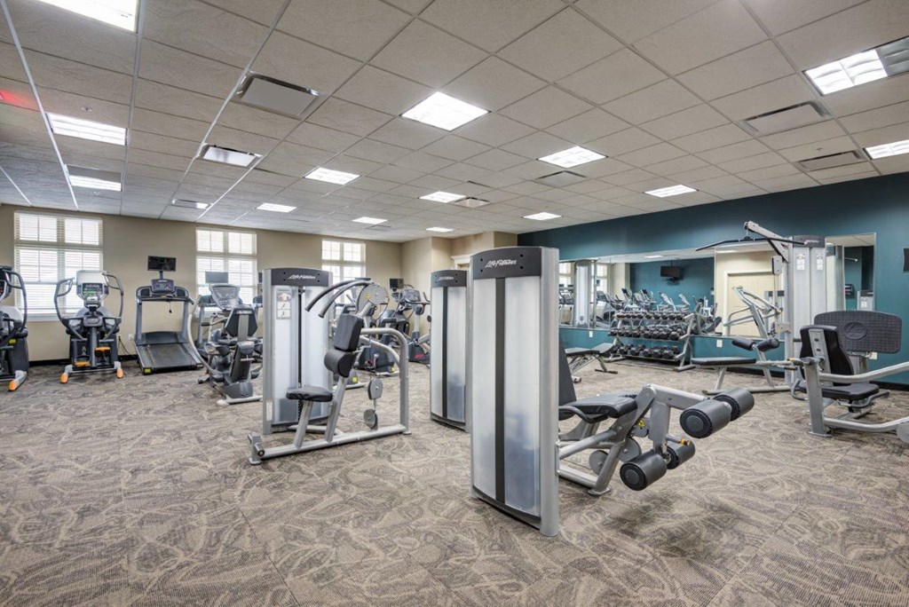 a gym with weights and cardio equipment in a building