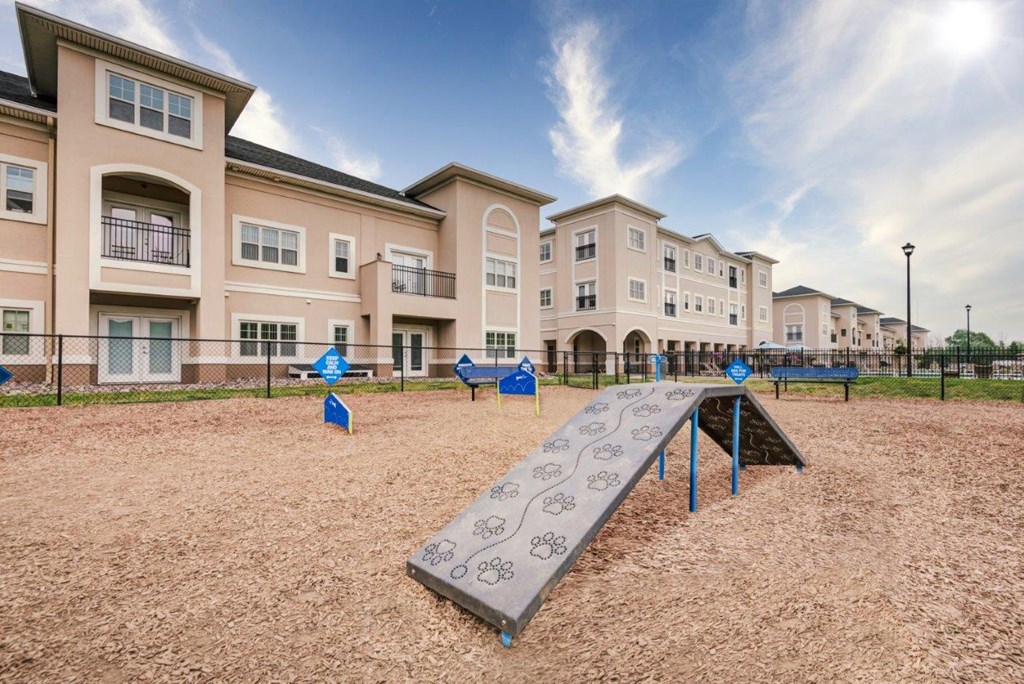 a playground with a slide and benches in front of apartment buildings