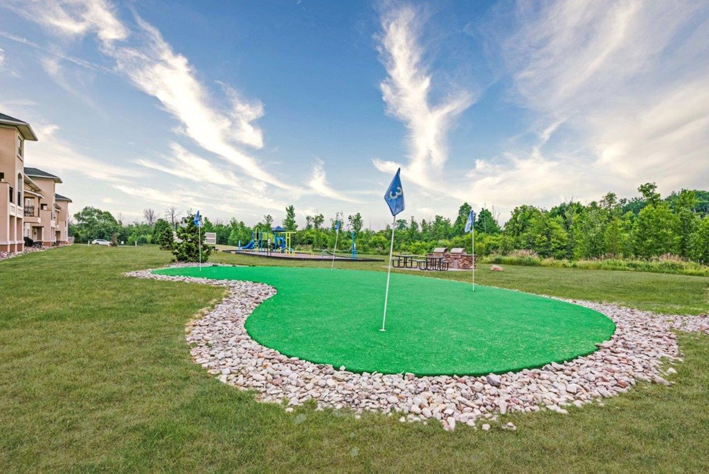 a putting green with a blue flag on top of it