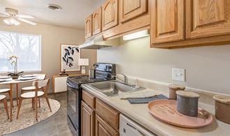 a kitchen with wooden cabinets and a sink and a table with a chair