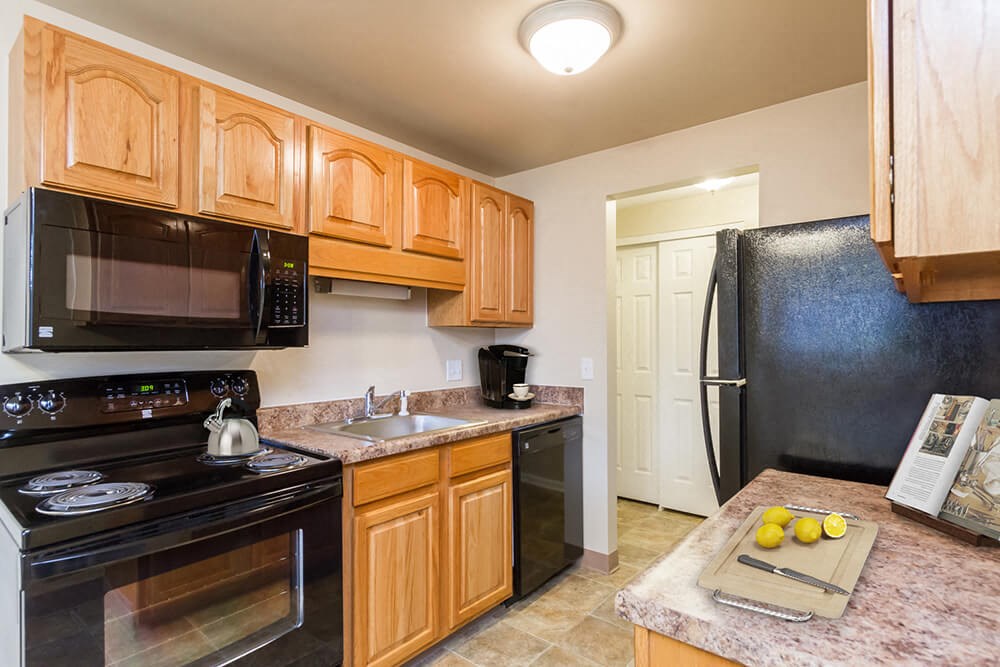 a kitchen with black appliances and wooden cabinets