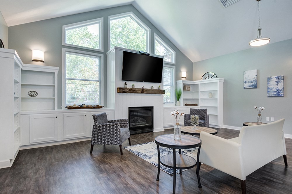 a living room with a large window and a table and chairs