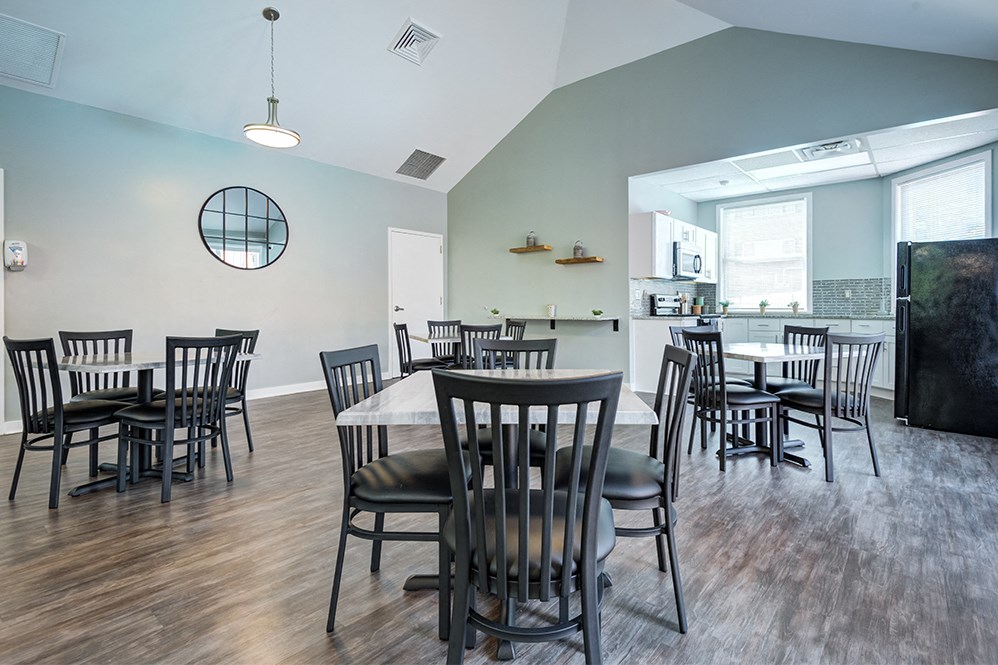 a large dining room with tables and chairs and a kitchen