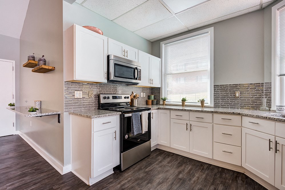 a kitchen with white cabinets and a stove and a microwave