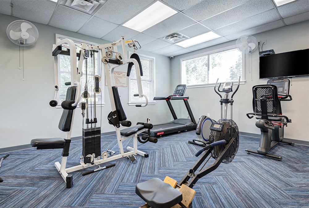 a gym with weights and cardio equipment in a resident amenity space