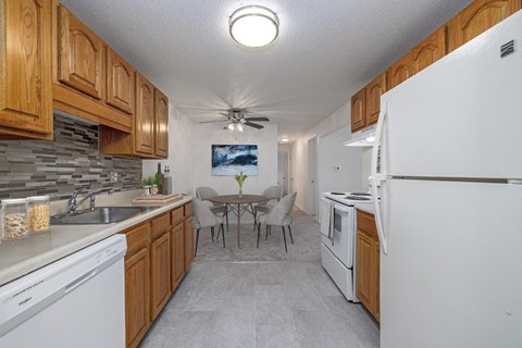 a kitchen with white appliances and a dining room with a table