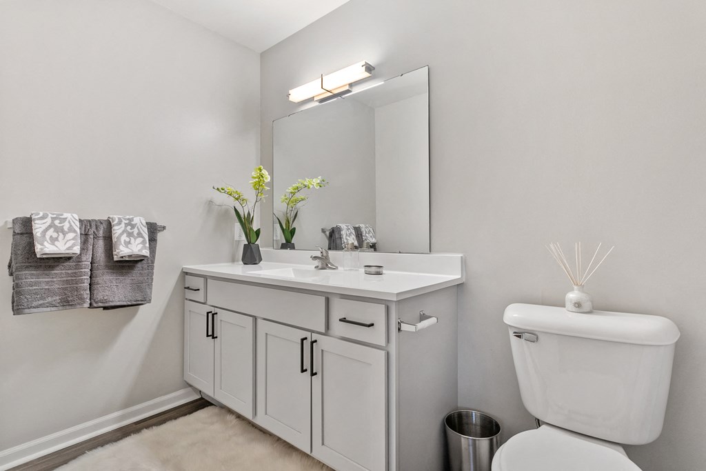 a white bathroom with a white toilet and a sink