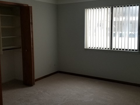 an empty room with a window and a closet