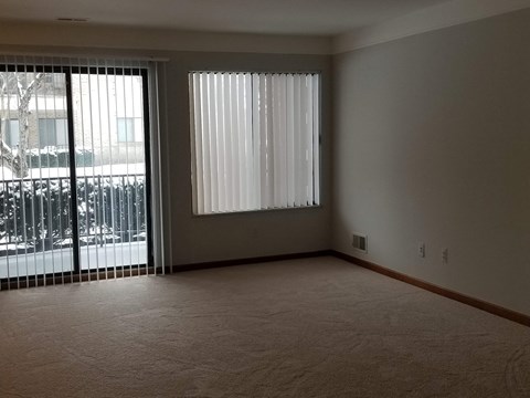 an empty living room with a large window and