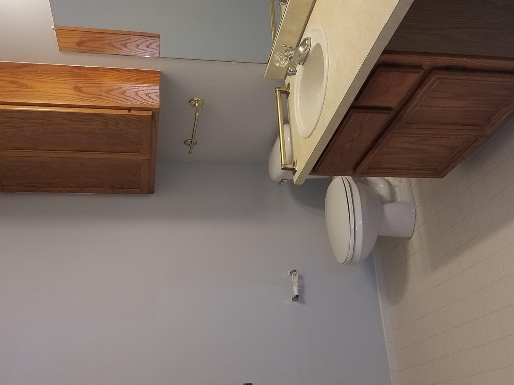 a bathroom with a toilet and wooden cabinets