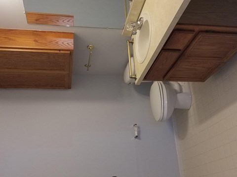 a bathroom with a toilet and wooden cabinets