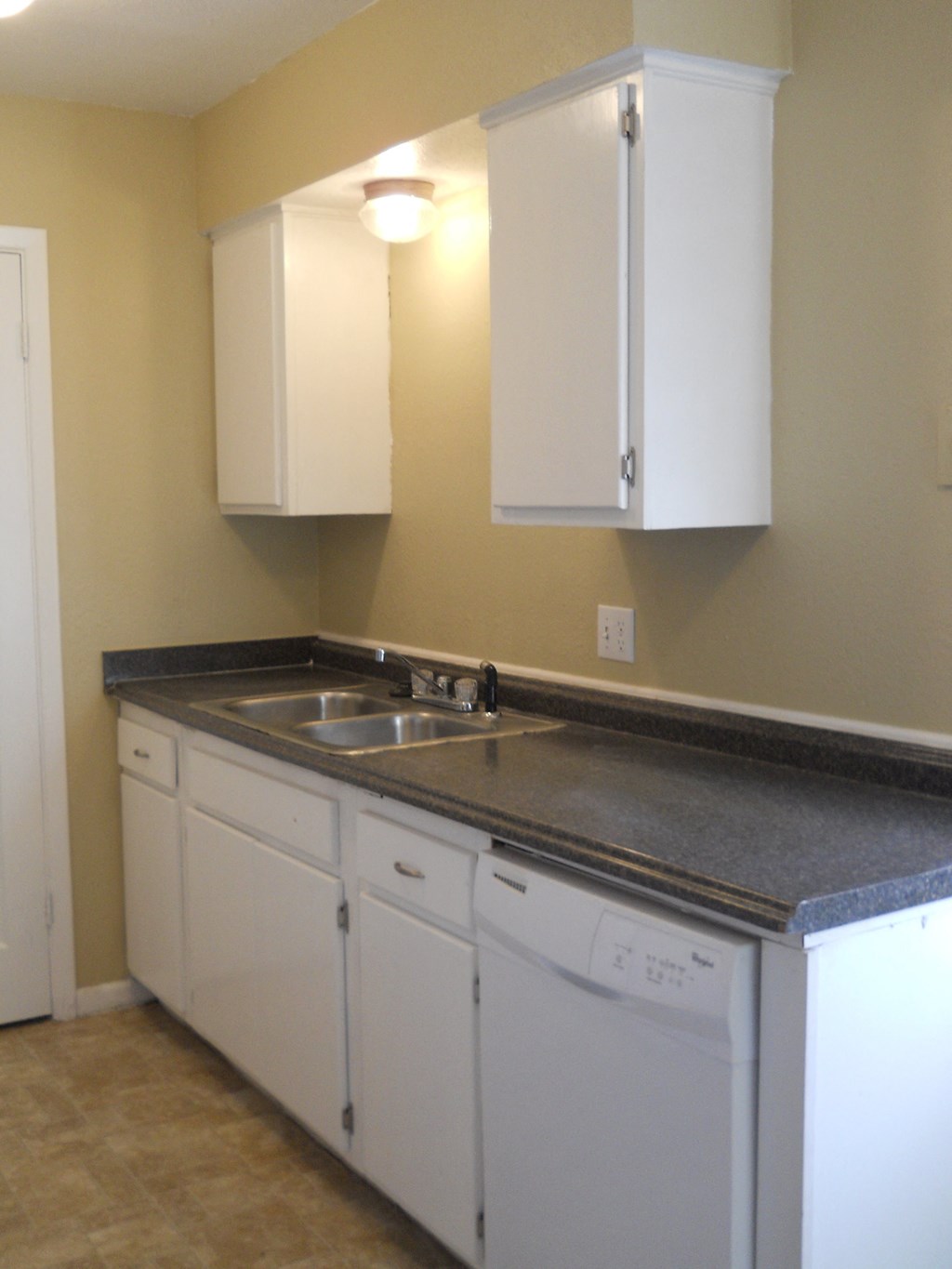 a kitchen with white cabinets and a sink and a dishwasher