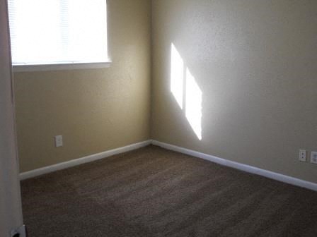 an empty room with a window and a carpet