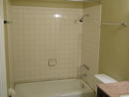 a white bathroom with a tub and a toilet