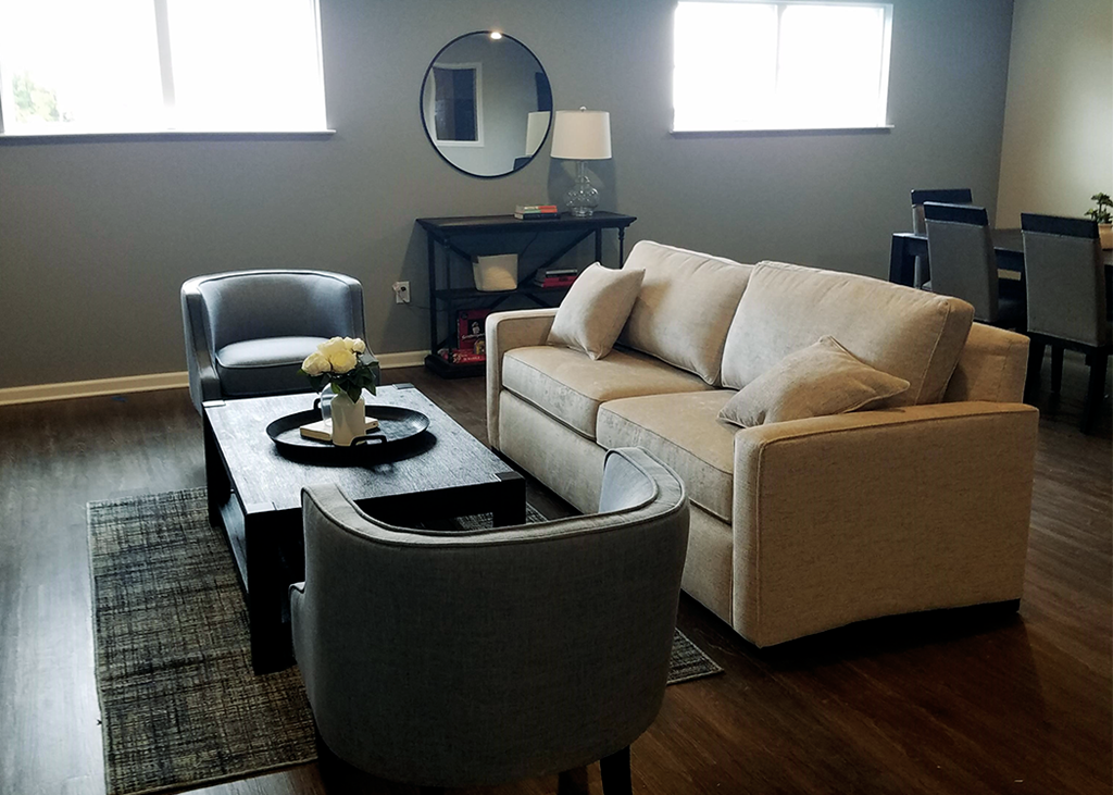 a living room with a couch and chairs and a coffee table