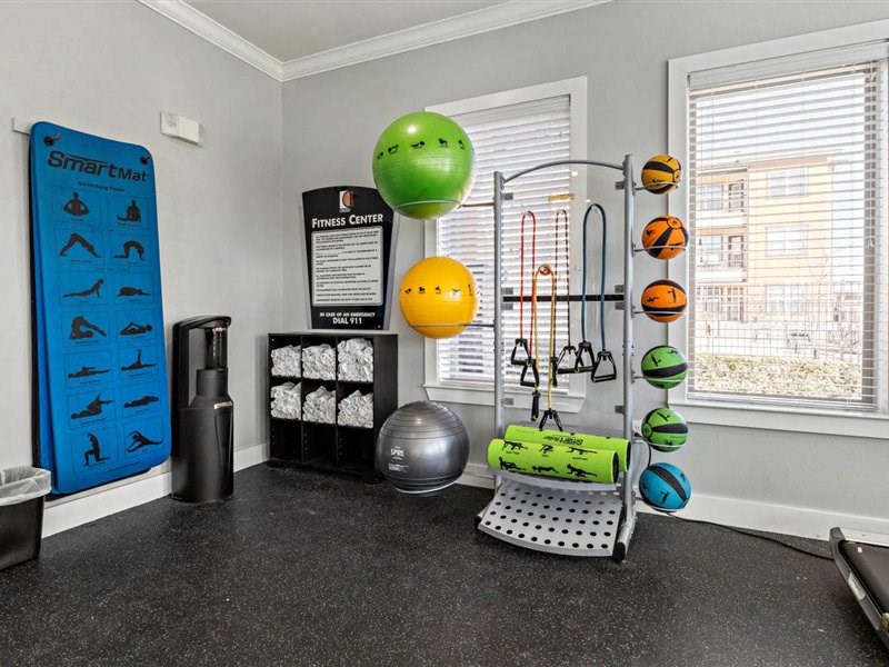 A room with a SmartFit wall hanging and a variety of exercise equipment.