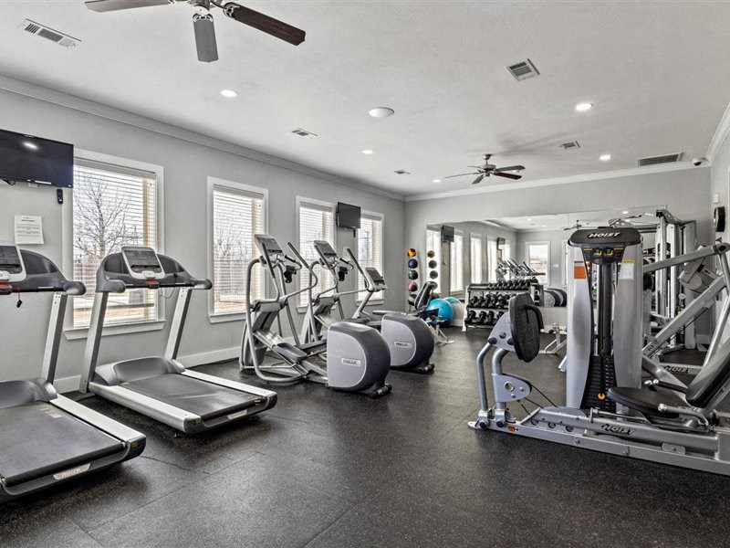 A spacious gym with treadmills, elliptical machines, and other exercise equipment.