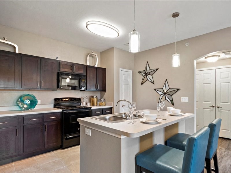 A kitchen with a table and chairs set for two.