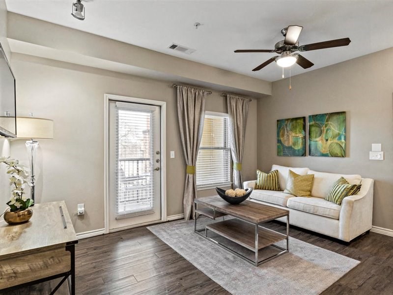 A living room with a white couch, a coffee table, and a ceiling fan.