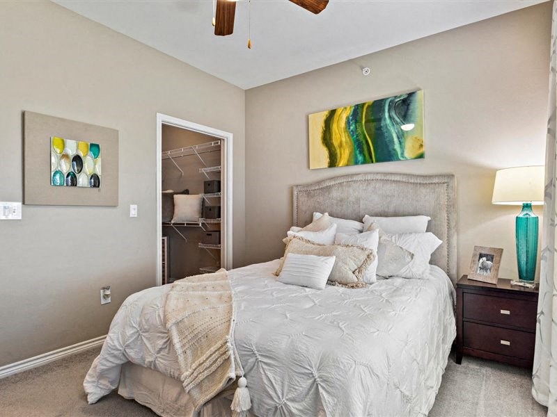 A bedroom with a large bed and a ceiling fan.