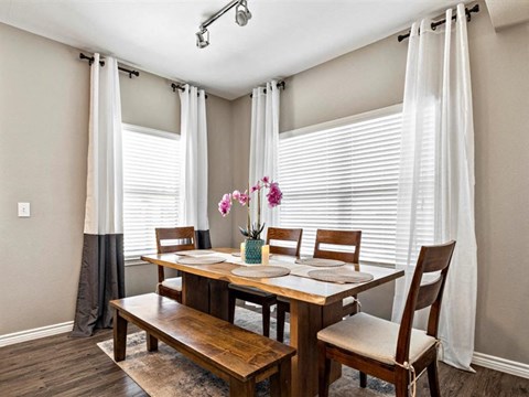 A dining room with a wooden table and chairs.