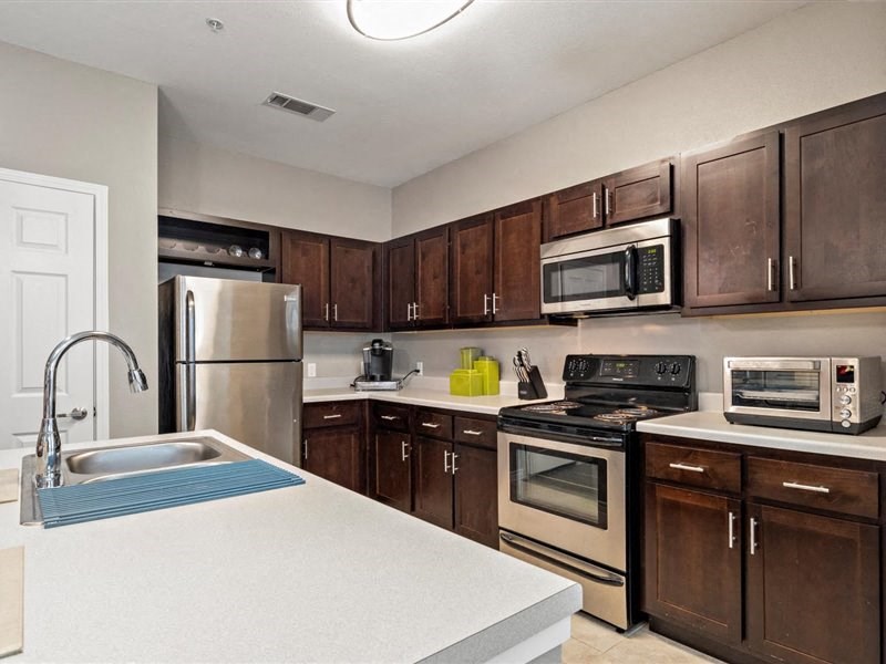 A kitchen with brown cabinets and a white counter.