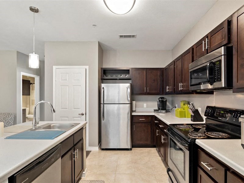 A kitchen with brown cabinets and a white counter.