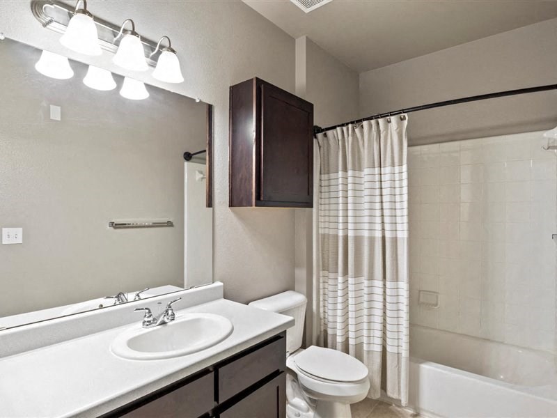 A bathroom with a white sink and a white toilet.