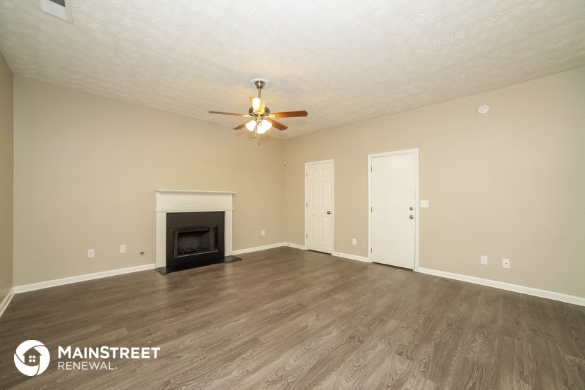 the living room with fireplace and ceiling fan
