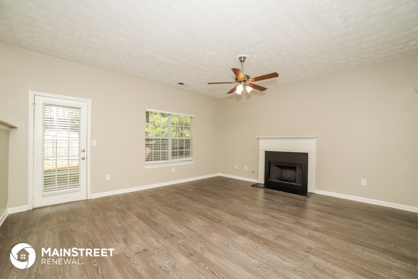 the living room with fireplace and ceiling fan