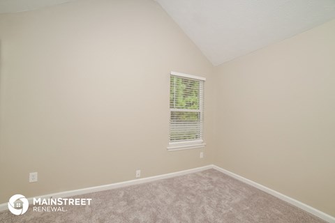 the upstairs bedroom with carpet and a window