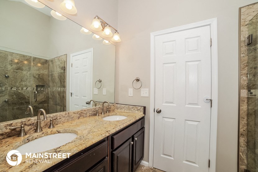 a bathroom with two sinks and a mirror and a shower