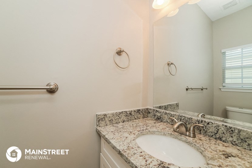 a bathroom with granite countertops and a sink and a toilet