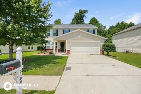 a white house with a driveway and a garage door