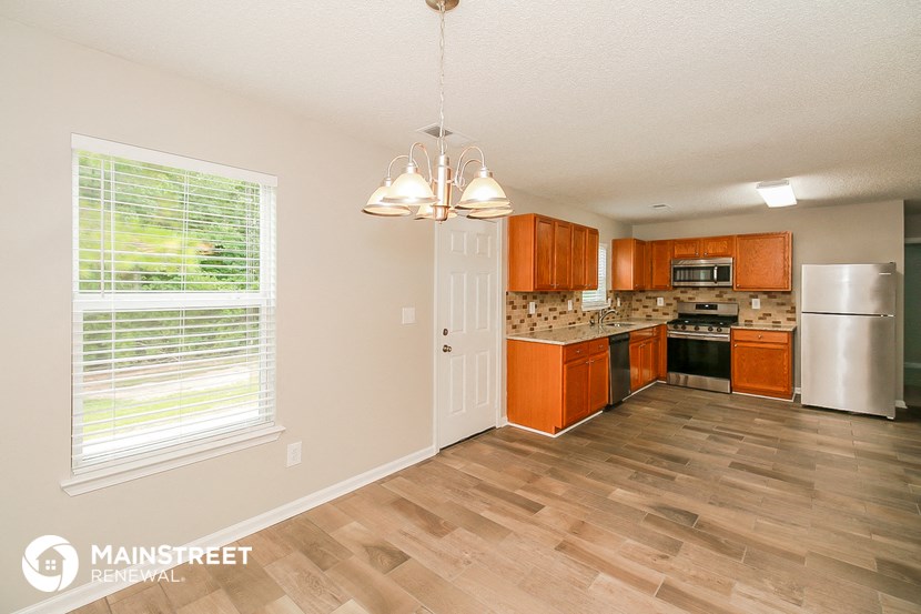 a kitchen with wood flooring and a large window