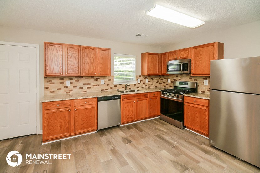 a kitchen with wooden cabinets and stainless steel appliances