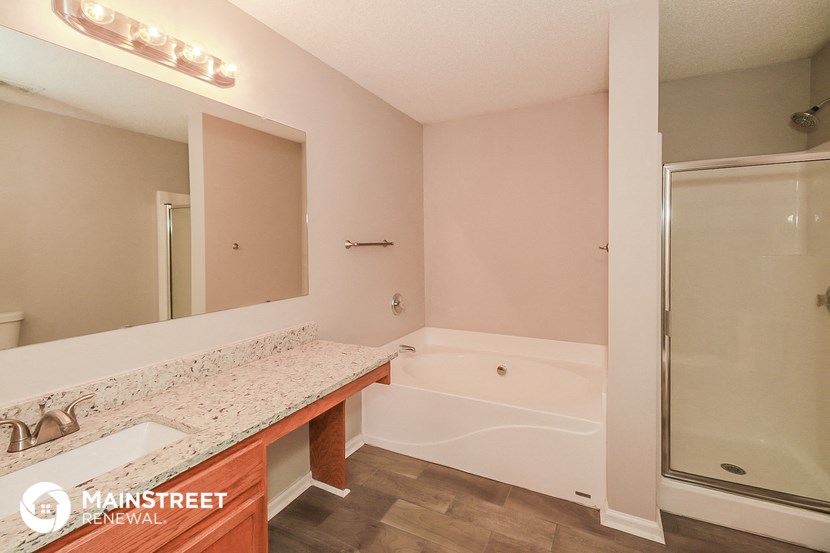 a bathroom with a tub and a sink and a mirror
