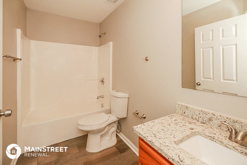 a bathroom with a toilet and a sink and a mirror