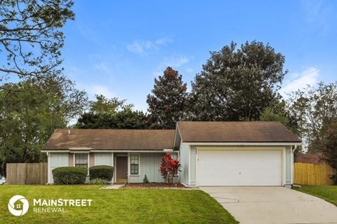 a home with a lawn and a white garage door