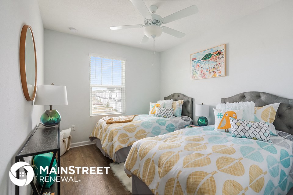 two twin beds in a bedroom with a ceiling fan